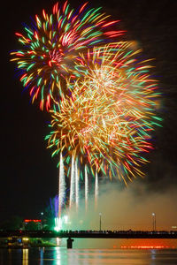 Firework display over river at night