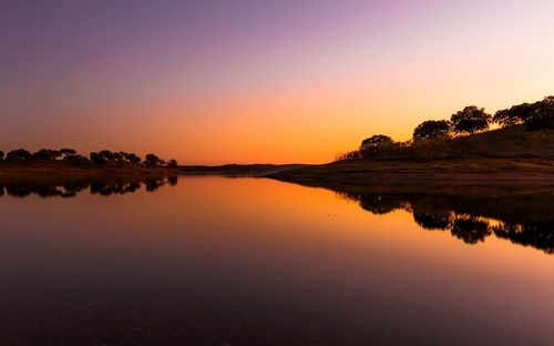 Scenic view of calm lake at sunset