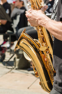 Midsection of man playing trumpet in city