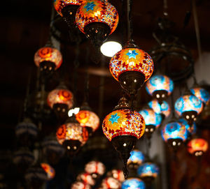 Low angle view of illuminated pendant lights hanging from ceiling