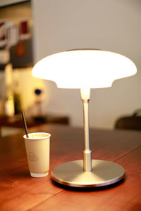 Close-up of illuminated lamp on table at home