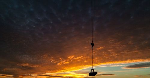 Low angle view of silhouette tower against dramatic sky