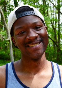 Close-up portrait of smiling young man in forest
