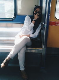 Woman sitting on seat in train