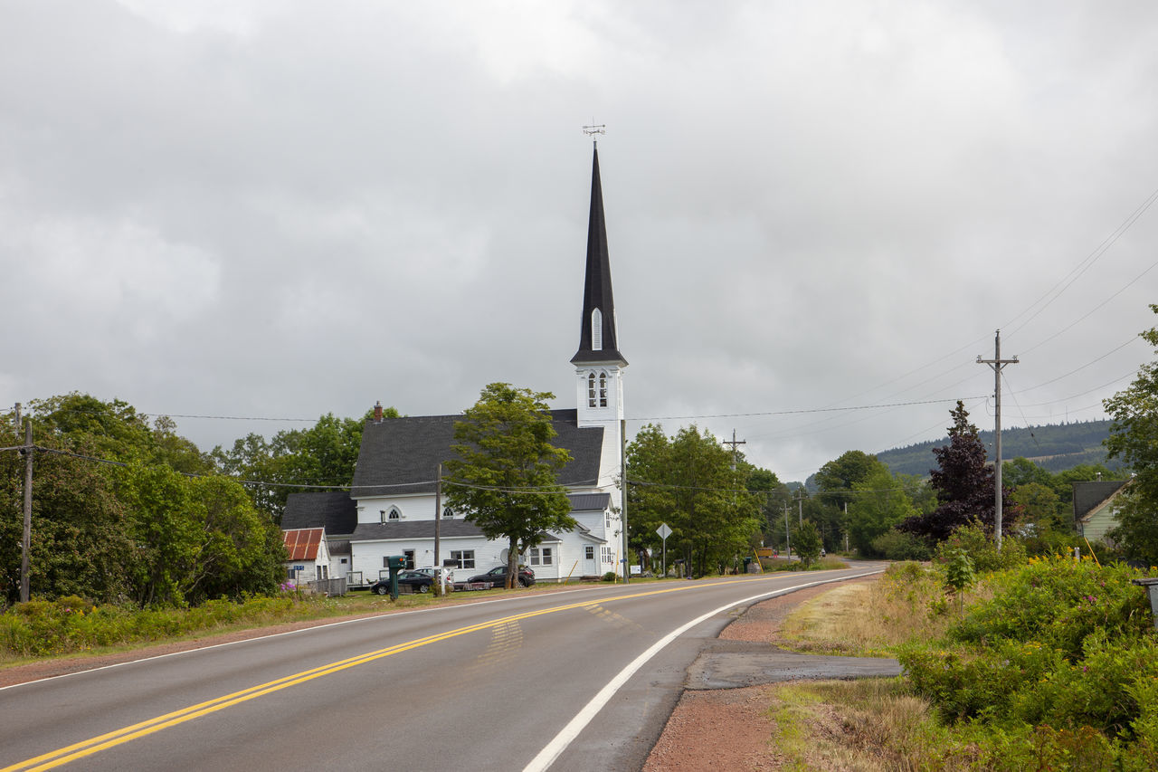 ROAD BY BUILDINGS AGAINST SKY