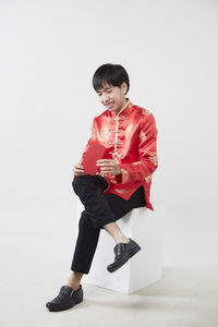 Full length of boy standing against white background