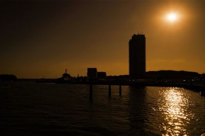 Silhouette buildings against sky during sunset