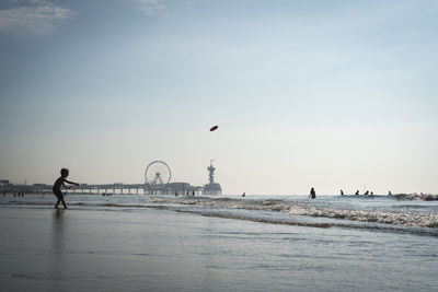 People on beach against sky