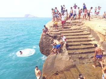 High angle view of people on rock by sea