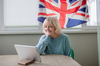 Young woman using laptop while sitting on sofa at home