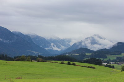 Scenic view of grassy landscape against cloudy sky