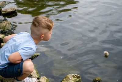 Small boy playing on a pond