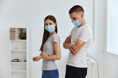 Young couple standing against wall