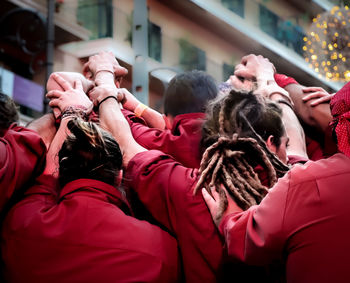 Rear view of sports team huddling