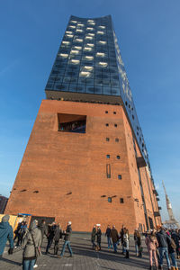 Low angle view of people against blue sky