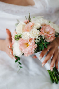 Close-up of bride holding bunch of flowers