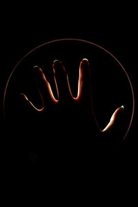 Close-up of human hand against black background