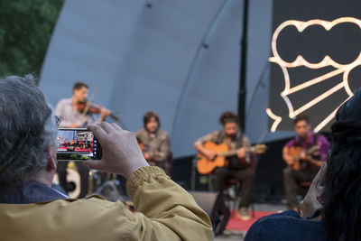 People photographing at music concert