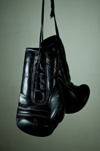 Close-up of shoes hanging against colored background