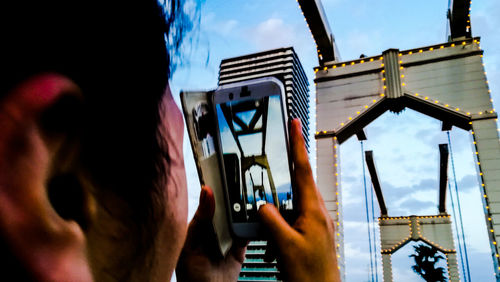 Low angle portrait of man against building against sky