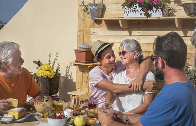 Cheerful family having food while sitting outdoors