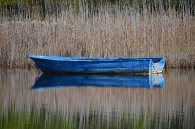 Boat moored on grass by lake