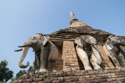 Low angle view of statue against temple