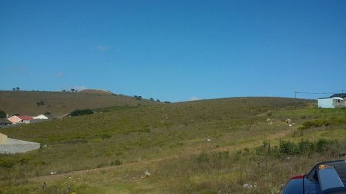 Scenic view of grassy field against clear sky