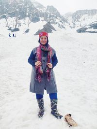 Portrait of smiling couple standing on snow covered mountain