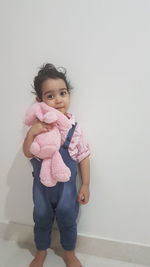 Portrait of smiling girl against wall at home