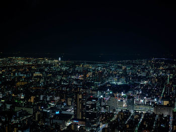 Illuminated cityscape against sky at night