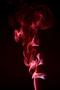 Red smoke against black background