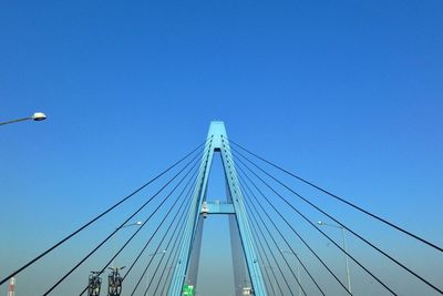 Low angle view of suspension bridge against clear blue sky