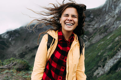 Young happy laughing carefree woman with hair blowing in the wind.