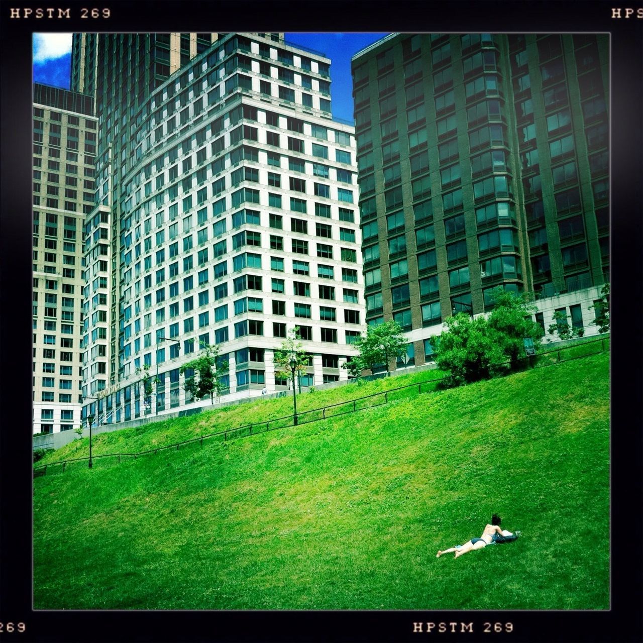 transfer print, building exterior, architecture, grass, built structure, auto post production filter, green color, lawn, city, building, grassy, day, tree, outdoors, no people, sky, residential building, sunlight, field, blue