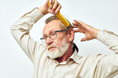 Midsection of man with arms crossed against white background