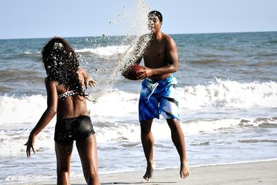 Couple playing on shore at beach