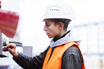 Portrait of boy wearing hat holding camera