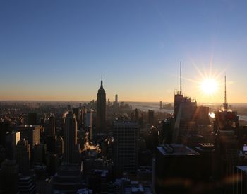 Modern buildings in city against sky during sunset