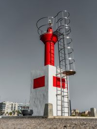 Low angle view of lighthouse against building against sky