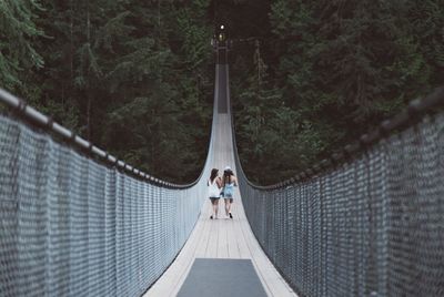 Women walking on rope bridge