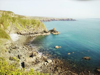 High angle view of rocks and sea against sky