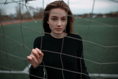 Portrait of young woman in cage