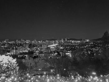 Illuminated cityscape against clear sky at night