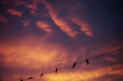 Low angle view of clothespins on string against sky