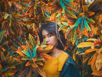 Portrait of woman standing by plants during autumn