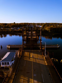 Pier over lake against clear blue sky