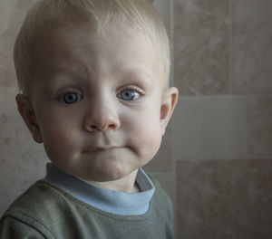 Portrait of cute baby boy against wall at home