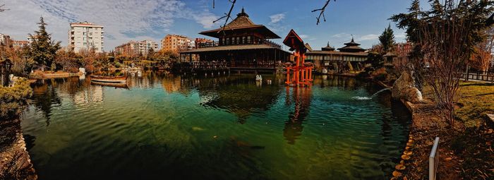 Panoramic view of lake by building against sky