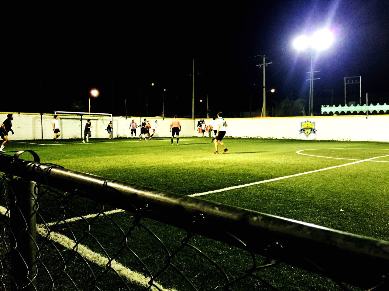 large group of people, sport, illuminated, grass, green color, night, sportsman, green, competitive sport, soccer, competition, teamwork, practicing, football, playing field, outdoors